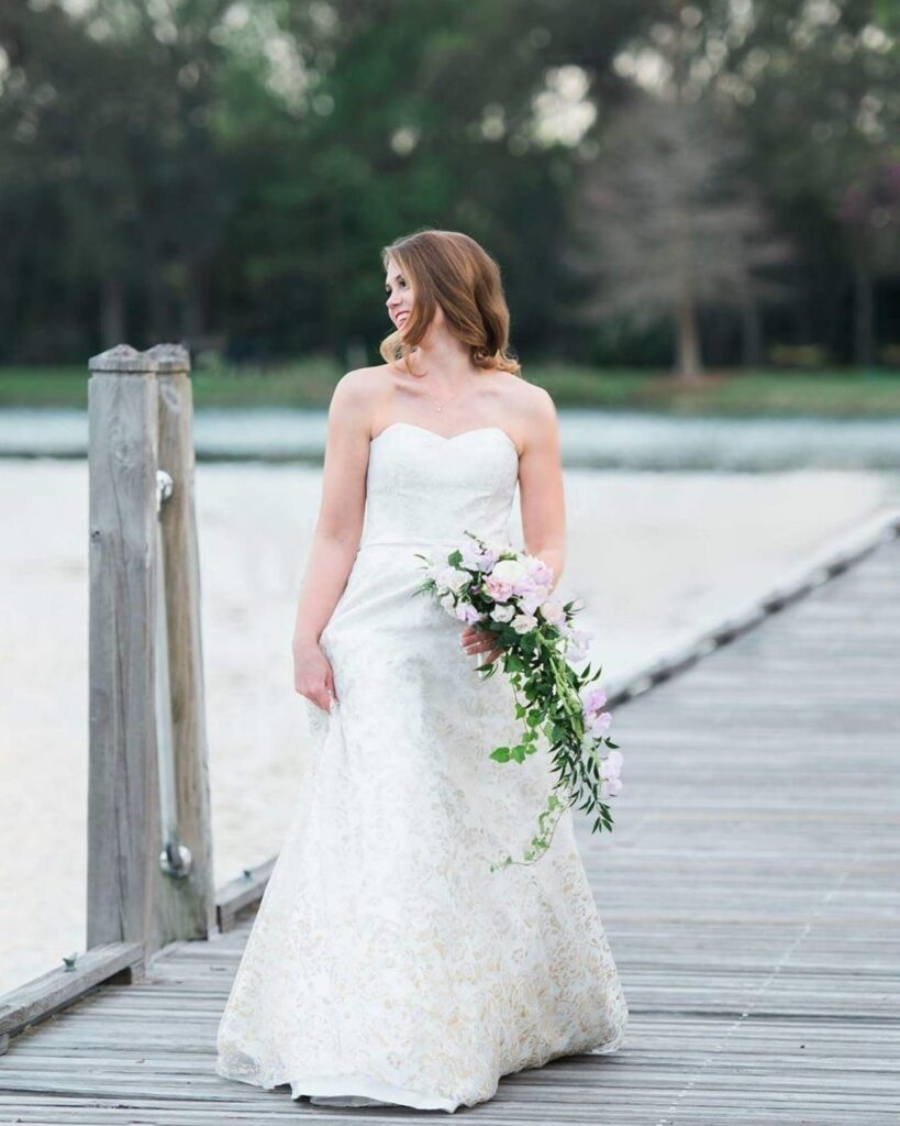 bride smiling while walking down pier over the water at Bohemian Hotel Celebration